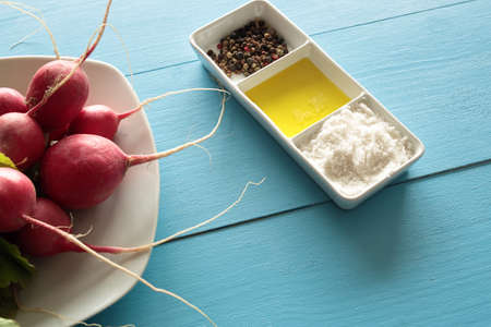 Radishes on a white plate on wooden backgroundの写真素材
