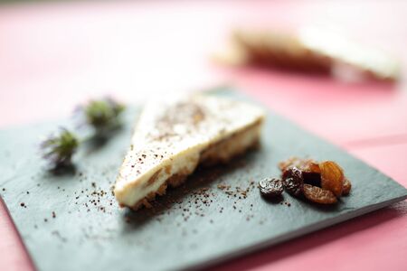 White chocolate cheesecake on a container board and pink backgroundの写真素材