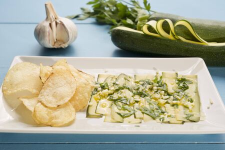 Agrios vegans and chips on a wooden background painted blueの写真素材