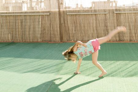girl playing on the terrace on artificial turfの写真素材