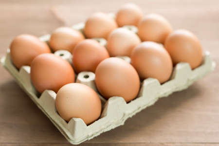 Chicken eggs in an egg cup on a wooden background