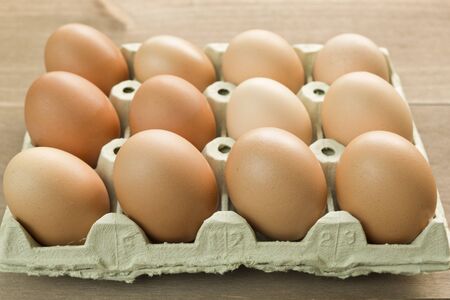 Chicken eggs in an egg cup on a wooden background