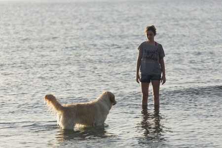 girl in the water with his dog in Santa Pola, Alicante, Spainの写真素材