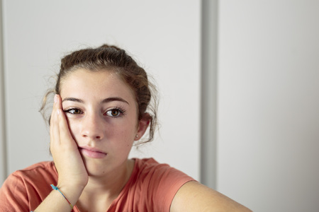 Teenager boring with your head resting on hand. Horizontal image with space for text and background clear.の写真素材