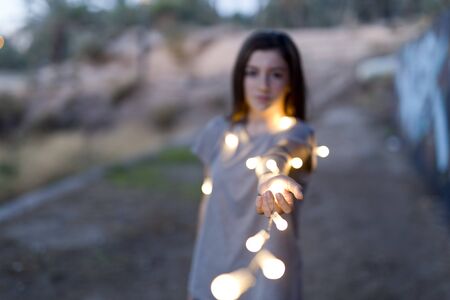 teenager with lights focused hands and face and body is out of focus.の写真素材