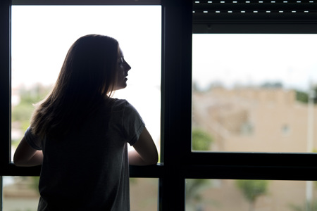 Teenager near a window. lighting backlit with copy space.