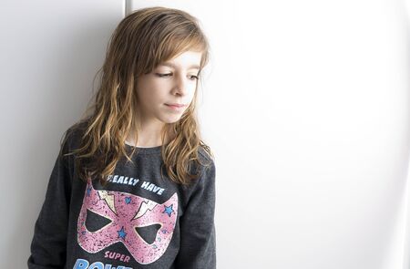 Portrait of little girl on a white background with soft artificial lightの写真素材