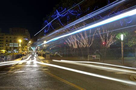 Elche, Spain. January 4, 2017: Street of the city of Elche at night, with lines of lights of vehicles by long exposition.のeditorial素材