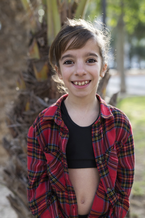Backlit portrait of a girl in a park. Vertical shot with natural lightの写真素材