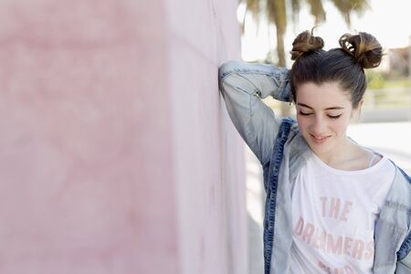 Portrait of teenage girl huddled on a purple wall.の写真素材