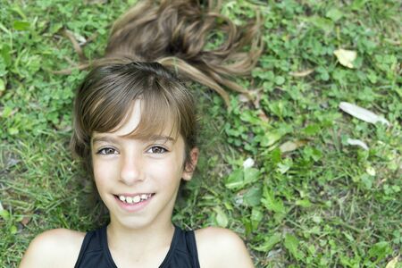 Face of a girl lying on the grass of a park of Pamplona in Spain.