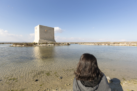Woman from behind contemplating the landscape of the Natural Park of Las Salinas in Santa Pola, province of Alicante, Spain.のeditorial素材