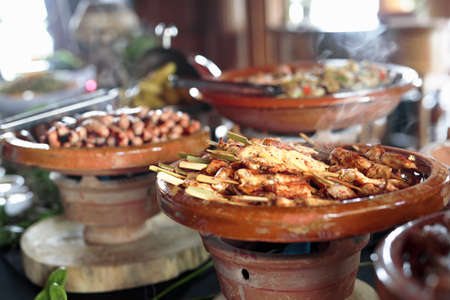 Cooked Belgian food placed in ceramic containers with a fire underneath to keep it warm.の写真素材