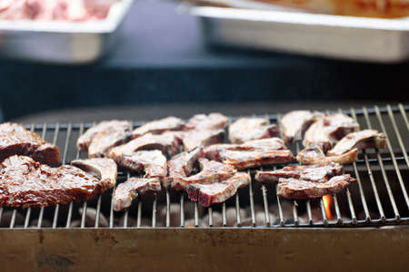 Meat being grilled on a barbecue in a Belgian restaurant. Daytime shot with natural light and selective focus.の写真素材