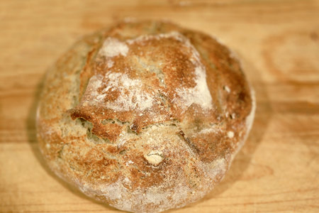 Homemade sourdough bread in a conventional oven. Daytime shot with natural light and selective focus.の写真素材