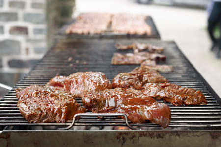 Meat being grilled on a barbecue in a Belgian restaurant. Daytime shot with natural light and selective focus.の写真素材