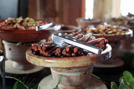 Cooked Belgian food placed in ceramic containers with a fire underneath to keep it warm.の写真素材