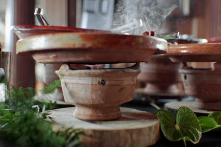 Cooked Belgian food placed in ceramic containers with a fire underneath to keep it warm.の写真素材