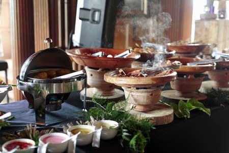 Cooked Belgian food placed in ceramic containers with a fire underneath to keep it warm.の写真素材
