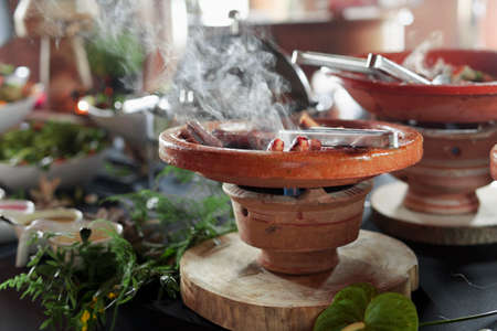 Cooked Belgian food placed in ceramic containers with a fire underneath to keep it warm.の写真素材
