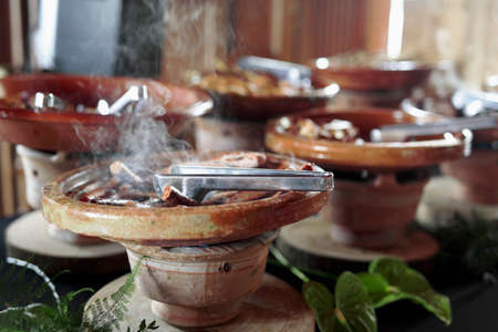 Cooked Belgian food placed in ceramic containers with a fire underneath to keep it warm.の写真素材