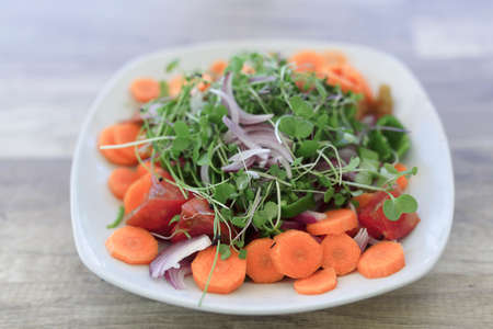 Vegan salad with organic products from Alicante, on a natural wooden table.の写真素材
