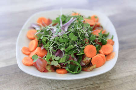 Vegan salad with organic products from Alicante, on a natural wooden table.の写真素材