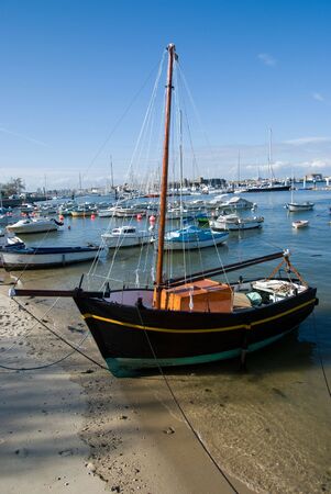 Black sailing ship on the beachの写真素材