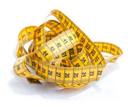 Tangled tape measure against a white backgroundの写真素材