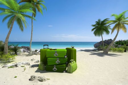 Pile of green luggage on a tropical beachの写真素材