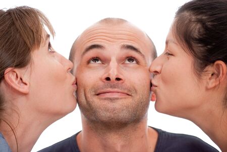 A man kissed by two girls on a white backgroundの写真素材