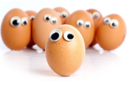 A group of eggs with eyes looking aroundの写真素材