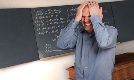 Desperate man in a class with complicated formulae in the blackboard