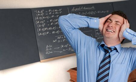 Desperate man in a class with complicated formulae in the blackboardの写真素材