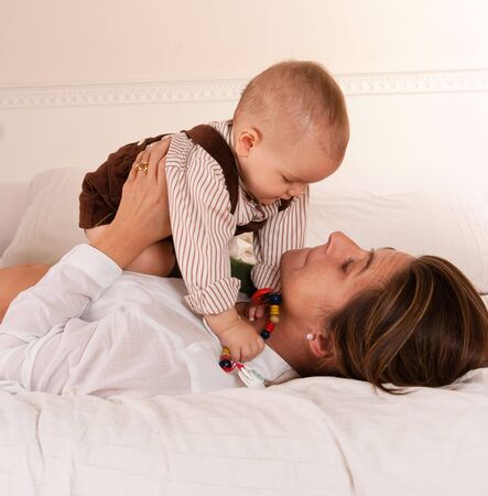 
Woman lying on a bed playing with her baby boy
の写真素材