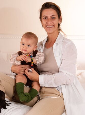 
Woman sitting on a bed playing with her baby boy
の写真素材