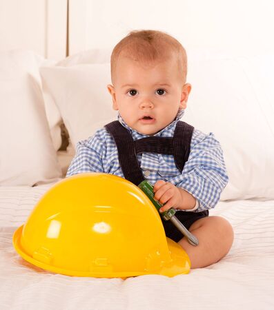 
Baby with a safety helmet and  a toy screwdriver
の写真素材