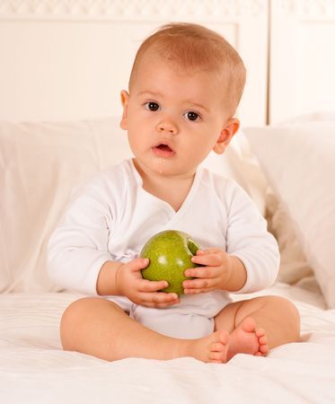 
Cute baby on a bodysuit holding a green apple
の写真素材