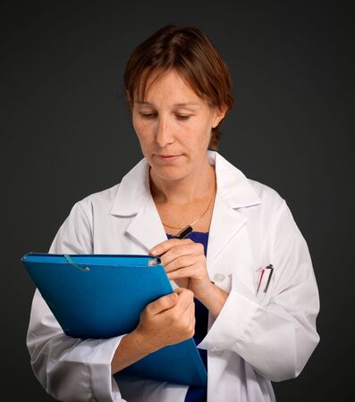 Woman with a medical uniform taking notesの写真素材