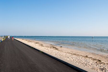 Beach road with cyclist on a fine summer dayの写真素材