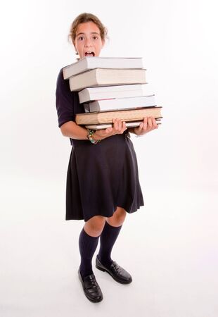 Schoolgirl carrying a heavy pile of booksの写真素材