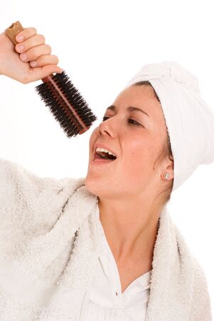 
Young girl in the bathroom singing using her brush as a microphone
の写真素材