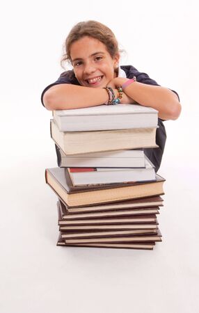 Happy looking student leaning on a pile of booksの写真素材