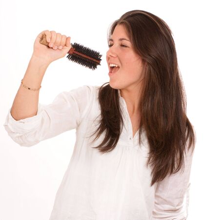 
Young girl singing using a brush as a microphone
の写真素材