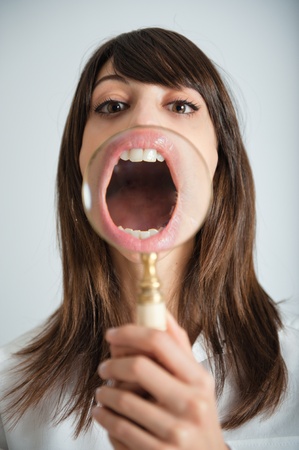 


Young woman showing her mouth thru a magnifying glass

の写真素材