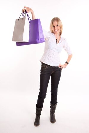 Young blond woman happily holding pair of shopping bags against a white background
の写真素材
