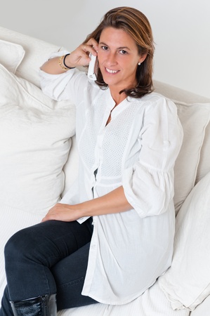 

Relaxed woman sitting on a sofa having a telephone conversation

の写真素材