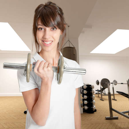 

Young woman in a gym lifting a dumbbell

の写真素材