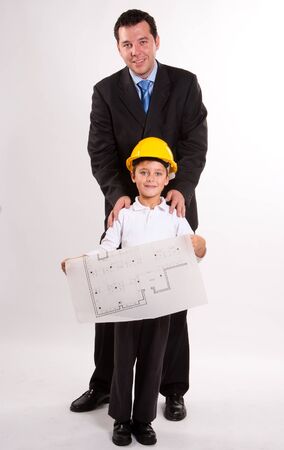 
Cute cheerful boy with a safety helmet, holding a plan, with his dad
の写真素材