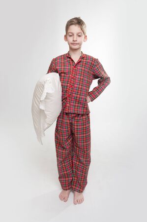 

Little boy with closed eyes in pyjamas holding a pillow 

の写真素材